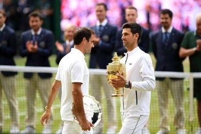 Federer pasa al lado de Djokovic en la ceremonia de entrega del trofeo de Wimbledon.