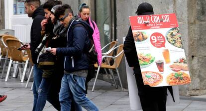 Una persona anuncia un restaurante en el centro de Madrid.