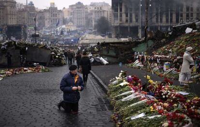 Un hombre se arrodilla en la plaza de la Independencia de Kiev, donde  murieron decenas de manifestantes.