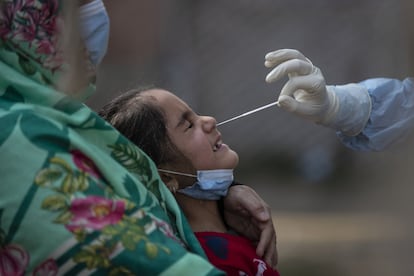 Un sanitario toma una muestra nasal a una niña para la prueba de la covid-19 en Srinagar, la Cachemira controlada por India.