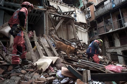 Bombeiros franceses trabalham com um cão de resgate entre as ruínas de uma casa em Katmandú (Nepal), no dia 28 de abril de 2015.