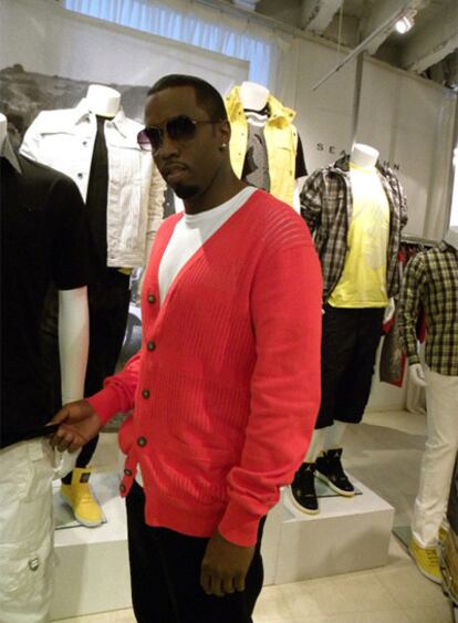El rapero Sean Diddy Combs posa junto a un modelo de su línea de ropa en una tienda de Nueva York.