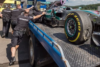 Técnicos de Mercedes tapan el coche de Rosberg tras pinchar en Spa.