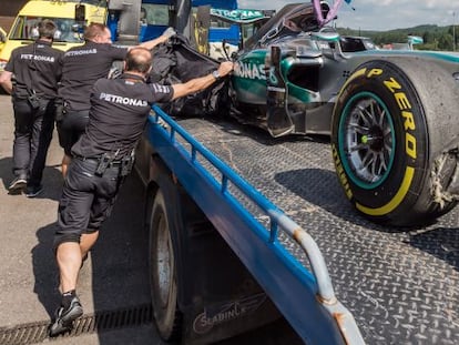 Técnicos de Mercedes tapan el coche de Rosberg tras pinchar en Spa.