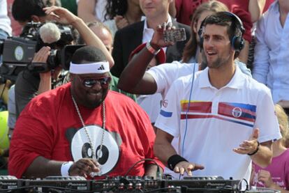 Djokovic pincha música junto al <i>dj</i> Ali Fitzgerald en su partido de exhibición del sábado en París.