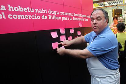 Un carnicero del Mercado de la Ribera coloca su idea en el panel de Bilbao Dendak.