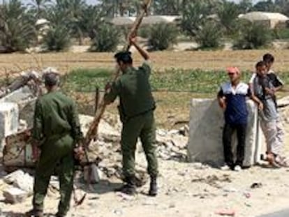 Dos policías colocan una bandera palestina cerca del asentamiento judío de Kfar Darom, en Gaza.