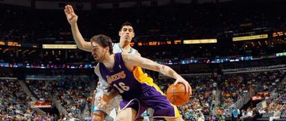 Pau Gasol, con el bal&oacute;n ante Gustavo Ayon, de los Hornets.