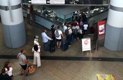 Pasajeros esperan en una fila para comprar billetes en la estación de Atocha, este lunes.