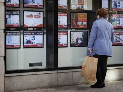 Una mujer mira el escaparate de una agencia inmobiliaria en Terrassa (Barcelona).