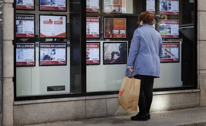 Una mujer mira el escaparate de una agencia inmobiliaria en Terrassa (Barcelona), el pasado marzo.