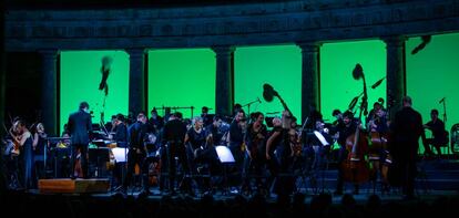 Los integrantes de la Mahler Chamber Orchestra abandonan el escenario del Palacio de Carlos V por la lluvia.