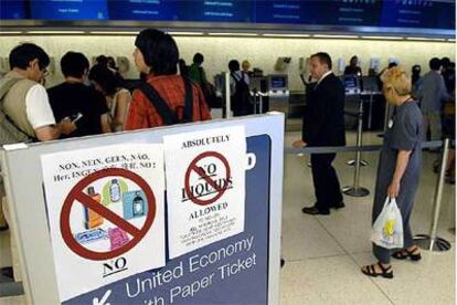 Unos carteles avisan de la prohibición de embarcar líquidos en el avión en el aeropuerto JFK de Nueva York.