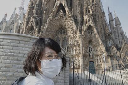 La Sagrada Família manté les portes tancades des d'aquest divendres per risc de contagi del coronavirus. Aquesta turista oriental, protegida amb mascareta, s'ha quedat sense poder entrar-hi.