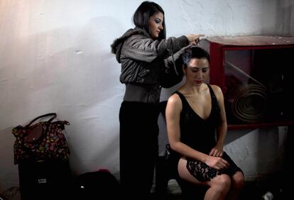 Una bailarina da los últimos retoques a su peinado entre bastidores.