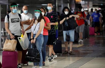 También se reanudan los viajes en tren entre provincias. Varias personas guardan su turno para coger el tren con destino a Cartagena este domingo en la estación de Sants de Barcelona.