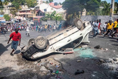 Um carro foi virado em uma das ruas de Porto Príncipe durante o sexto dia de protestos, em 12 de fevereiro de 2019.