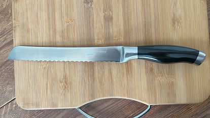 Cuchillo cortar pan sobre tabla de madera.