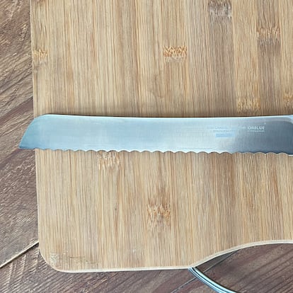 Cuchillo cortar pan sobre tabla de madera.