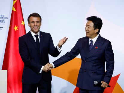 El presidente francés, Emmanuel Macron, saluda al actor chino Huang Bo en la inauguración de un evento al que ha asistido al poco de aterrizar en Pekín este miércoles.