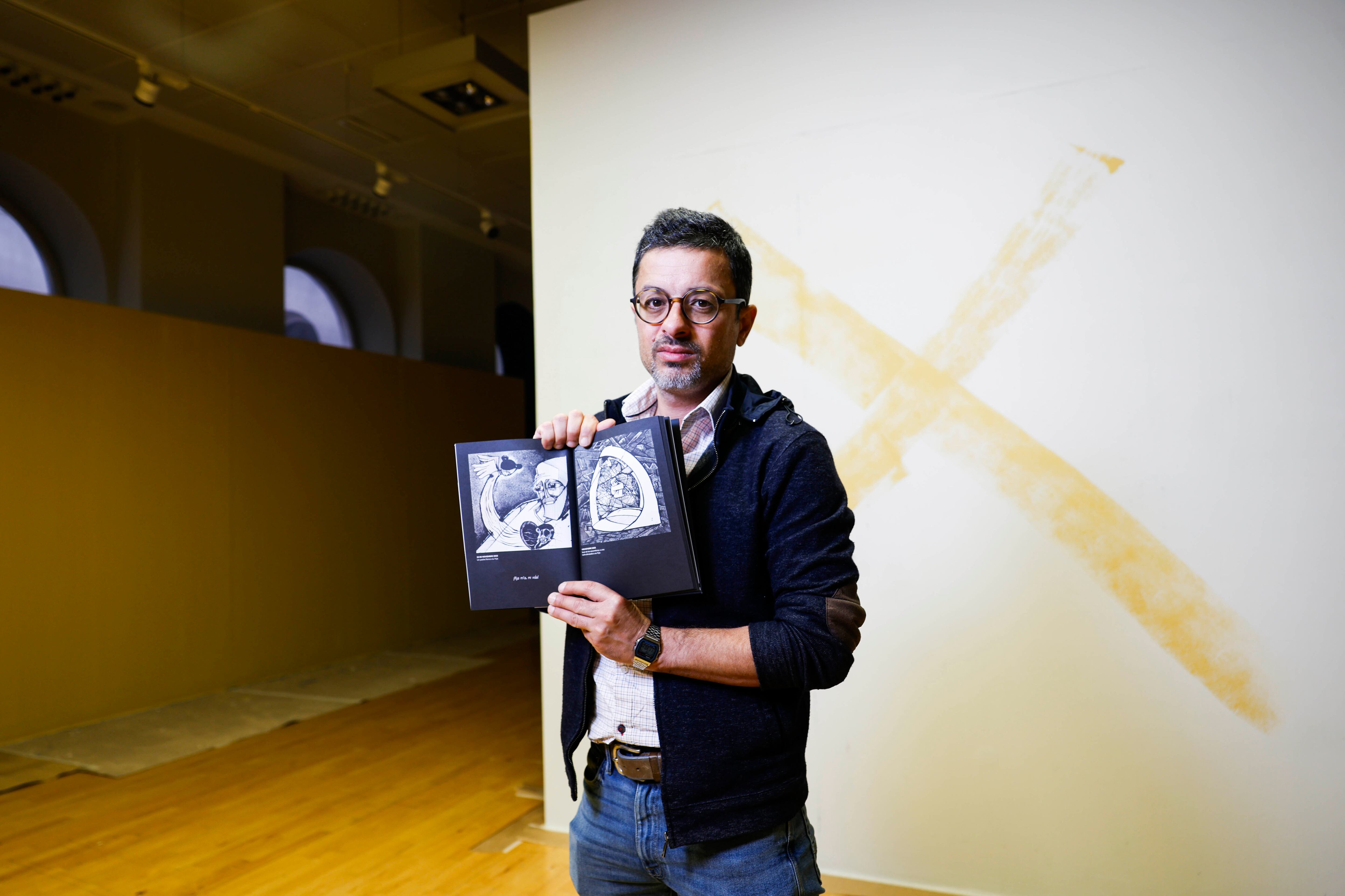 El dibujante palestino Mohammad Sabaaneh, con su libro de ilustraciones, el lunes en Casa Árabe, en Madrid.