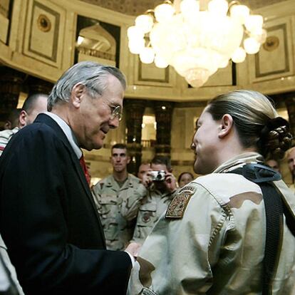 El secretario de estado de Defensa de EEUU, Donald Rumsfeld, saluda a una soldado de una unidad de infantería aerotransportada estadounidense, durante su visita a la localidad iraquí de Faluya.