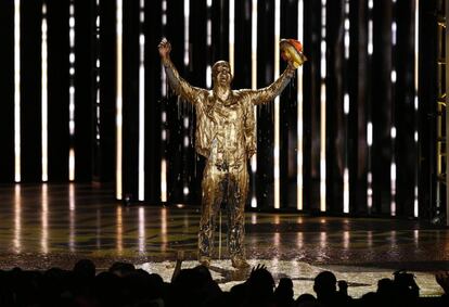 El nadador olímpico Michael Phelps es cubierto de pintura dorada durante la ceremonia de entrega del premio "Legend Award". 