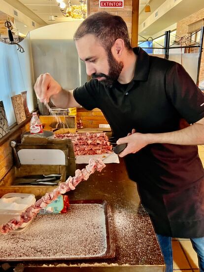 Alberto Puertas salando los pinchos de lechazo antes de ponerlos en la brasa.