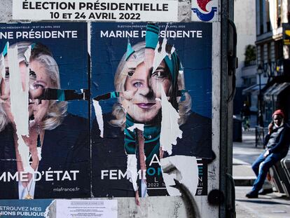 Carteles electorales de Marine Le Pen que han sido rasgados, este sábado en París.