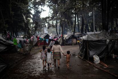 Una familia indígena camina por los corredores del campamento ubicado en el Parque Nacional de Bogotá.