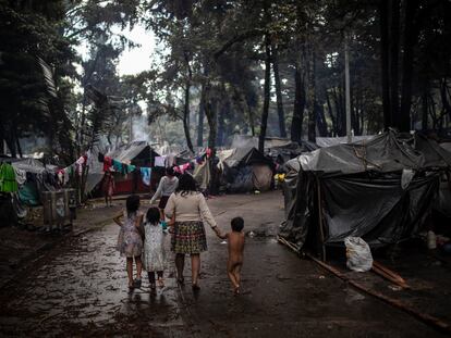 Una familia indígena camina por los corredores del campamento ubicado en el Parque Nacional de Bogotá.