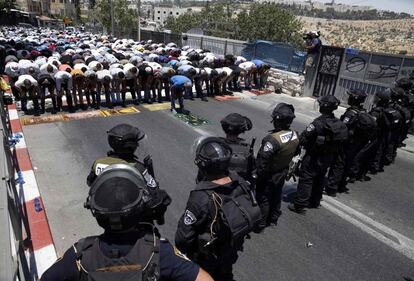 Una multitud de palestinos rezan el primer viernes del Ramadán frente a un cordón de la policía israelí en el barrio de Wadi al-Joz, en Jerusalén.