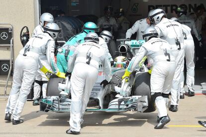 Los mecánicos de Mercedes introducen el Mercedes de Lewis Hamilton en el garaje tras la avería del británico que le obligó a abandonar la carrera.