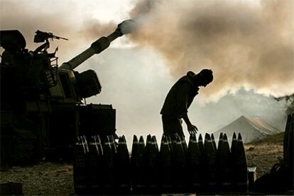 Un artillero israelí prepara la munición para el blindado que desde la línea de frontera bombardea el sur de Líbano.