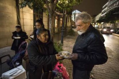 La vecina Gabriela García ofrece platos de arroz a las puertas del Samur Social.