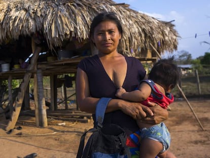 Una mujer de la tribu emberá sostiene en brazos a su mujer en Alto Playona, Panamá.