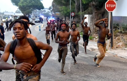 La valla que separa Ceuta de Marruecos ha vivido este viernes el salto de unos 150 inmigrantes que en torno a las siete de la mañana han logrado cruzar a territorio español. En la imagen, inmigrantes a la carrera tras saltar la valla.