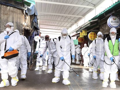 Trabajadores con trajes de protección desinfectan un mercado en Bupyeong, Corea del Sur, este lunes.