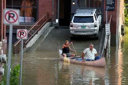 Two residents use a canoe to remove surgical supplies from the flood-damaged center, on July 11, 2023, in Montpelier, Vermont.