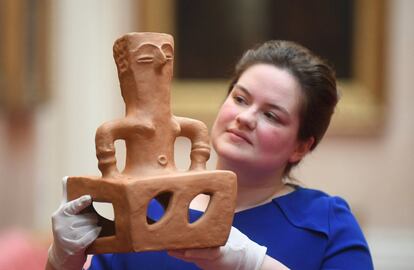 Una trabajadora del palacio de Buckingham muestra una figura de terracota que recibió Isabel II durante su visita a Macedonia en 2013