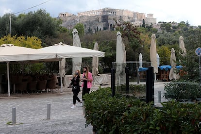 Dos mujeres en Atenas este miércoles, junto a un restaurante cerrado.