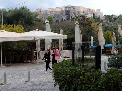 Dos mujeres en Atenas este miércoles, junto a un restaurante cerrado.