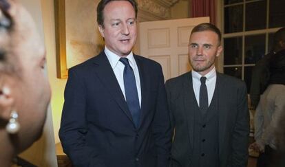 El primer ministro brit&aacute;nico David Cameron con  Gary Barlow, cantante y compositor principal del grupo.