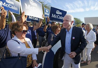 El senador republicano John McCain y su esposa (a la derecha), saludan a unos seguidores tras haber votado ayer en Phoenix.