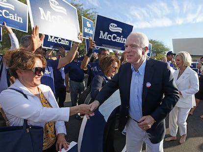 El senador republicano John McCain y su esposa (a la derecha), saludan a unos seguidores tras haber votado ayer en Phoenix.
