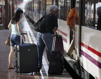 Tres pasajeros suben a un tren en la estación madrileña de Chamartín