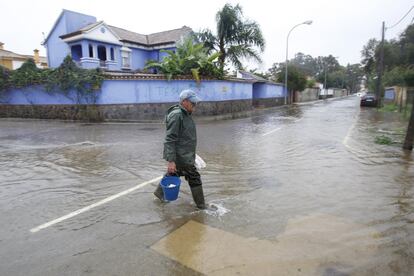 Un vecino cruza una calle inundada en la urbanización de Guadacorte en Los Barrios (Cádiz) tras el temporal en las provincias de Málaga y Cádiz. 