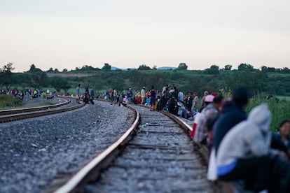 Migrants wait for a train heading north, in Huehuetoca (State of Mexico).