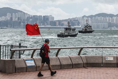 El principio "un país, dos sistemas", formulado por la China regida por los comunistas para gobernar Hong Kong después de 1997, ha sido defendido a ultranza por el presidente chino durante su discurso.  “No hay ninguna razón en absoluto para cambiar este tipo de buen sistema. Debemos mantenerlo en el futuro”, ha asegurado Xi. El líder chino también ha instado a desarrollar el sentimiento patriótico de los jóvenes hongkoneses, los grandes protagonistas de las protestas de hace tres años y que, según las encuestas, rechazan mayoritariamente identificarse como chinos. “Si los jóvenes tienen un futuro, Hong Kong tiene un futuro”, ha dicho el jefe de Estado. En la imagen, un hombre camina con una bandera china a lo largo del frente del puerto de Hong Kong.