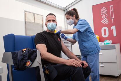Una sanitaria vacuna a un policía este miércoles en Valencia, tras reanudarse en España la campaña con AstraZeneca.